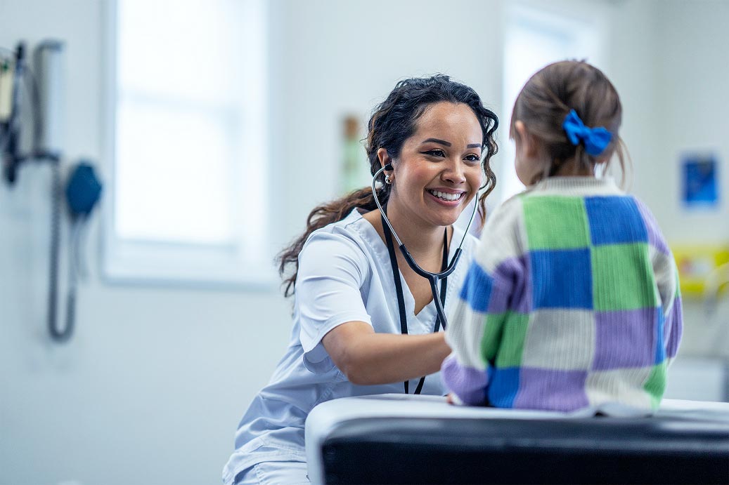 Infirmière souriante examinant une jeune patiente